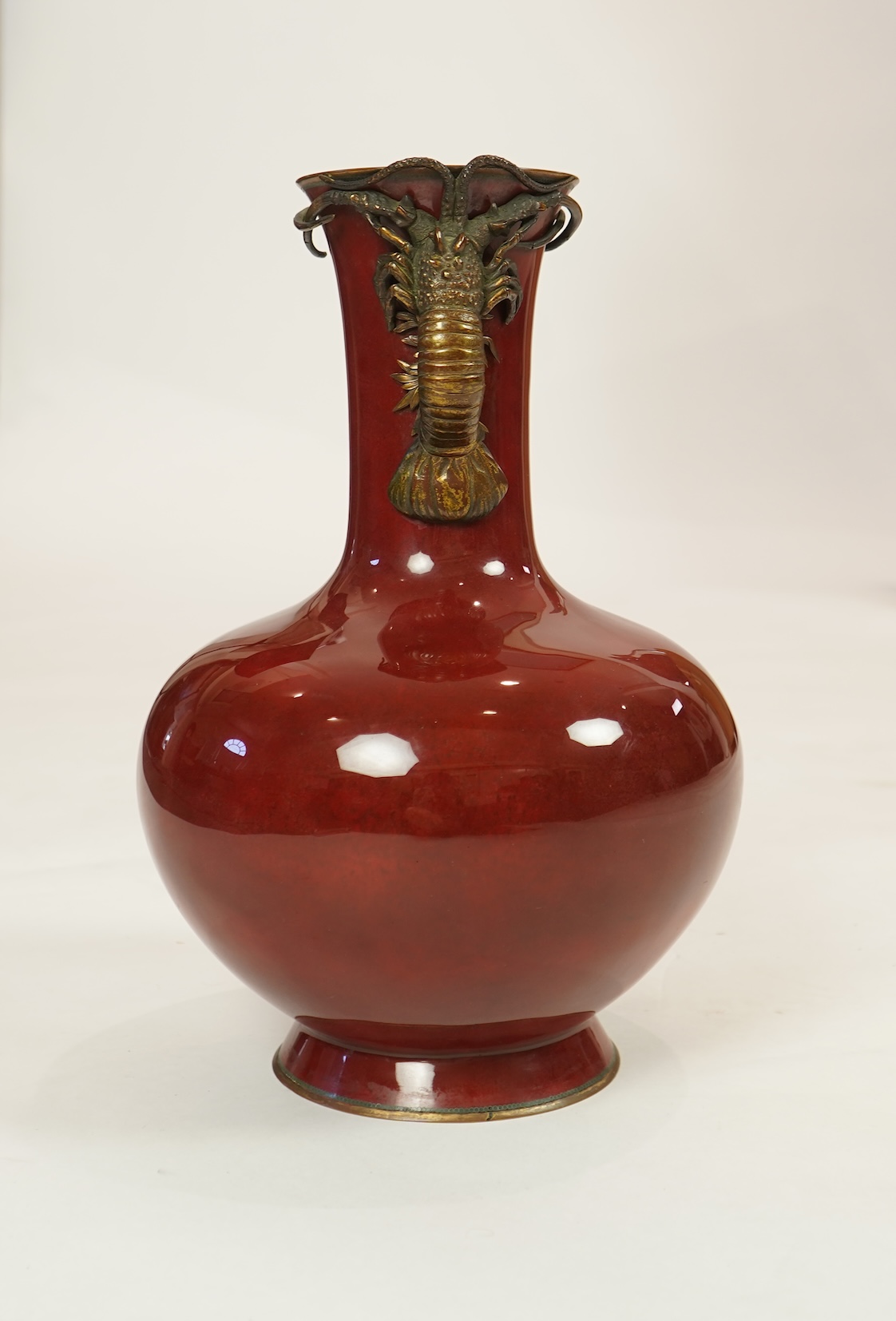 An unusual Japanese sang-de-boeuf ground cloisonné enamel and gilt metal mounted vase